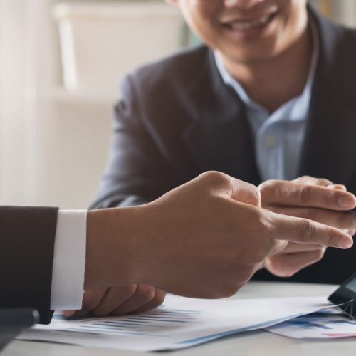 financial advisory services. Asian advisor showing plan of investment to clients in the consultancy office.